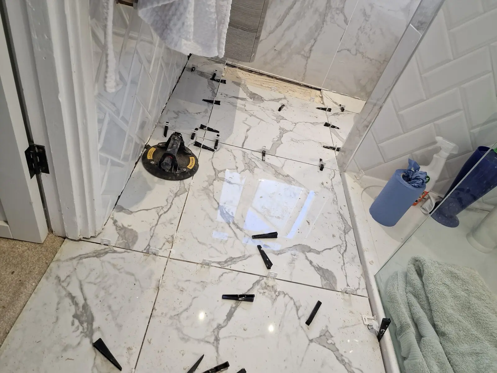 Large format bathroom floor tiles being fitted